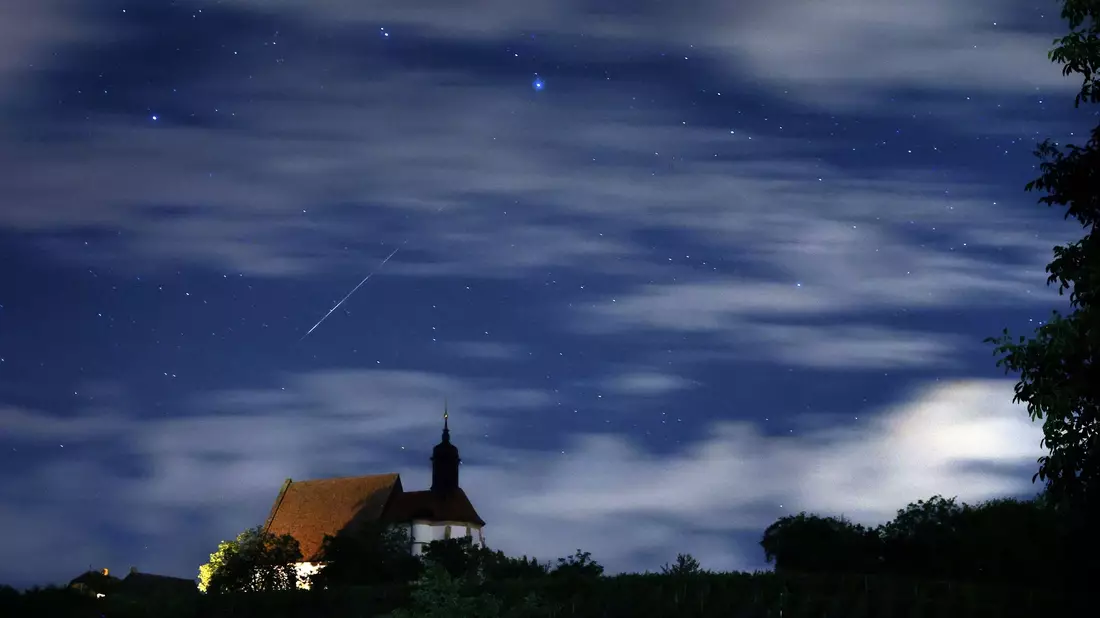 Eine Sternschnuppe verglüht am Himmel über der Wallfahrtskirche Maria im Weingarten. - Bild: Karl-Josef Hildenbrand/dpa