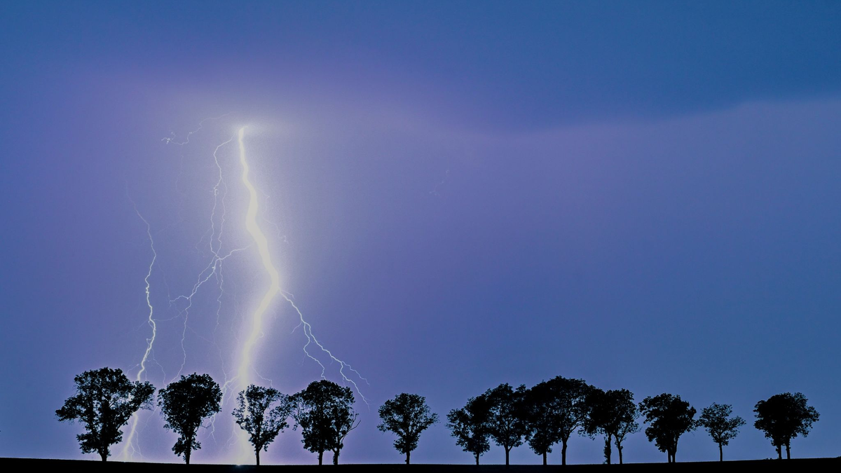 Ein Blitz eines Gewitters erhellt den Nachthimmel über der Landschaft im Osten des Landes Brandenburg. - Foto: Patrick Pleul/dpa