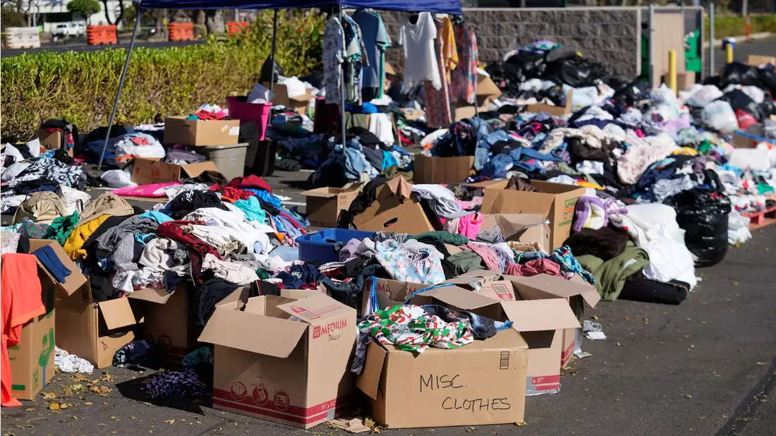 Gespendete Kleidung wird in Lahaina, Hawaii, auf einem Parkplatz gesammelt, nachdem die Waldbrände schwere Schäden verursacht haben. - Bild: Rick Bowmer/AP/dpa