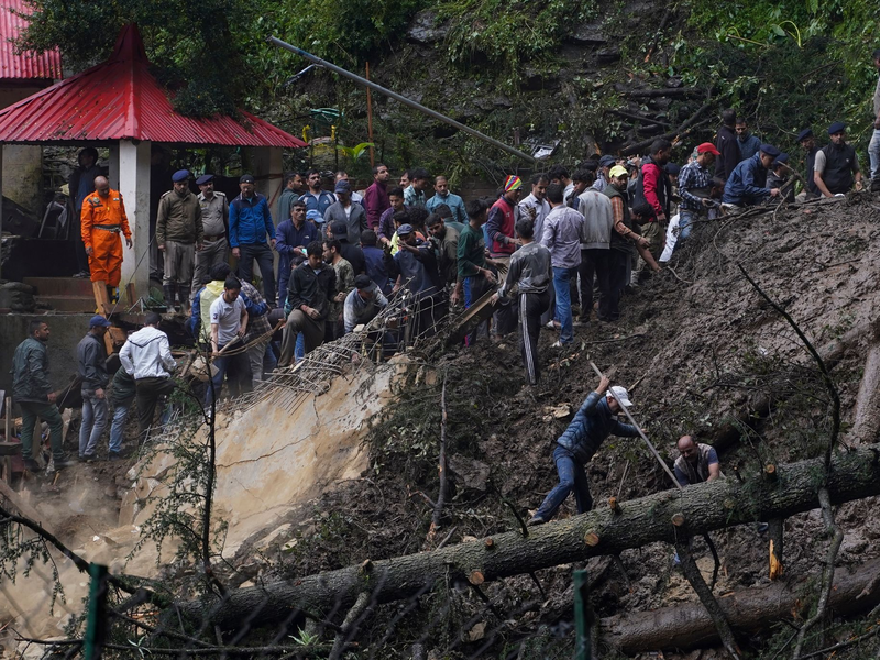 Rettungskräfte bei der Suche nach Menschen, die nach einem Erdrutsch in der Nähe eines hinduistischen Tempels verschüttet wurden. - Foto: Pradeep Kumar/AP/dpa