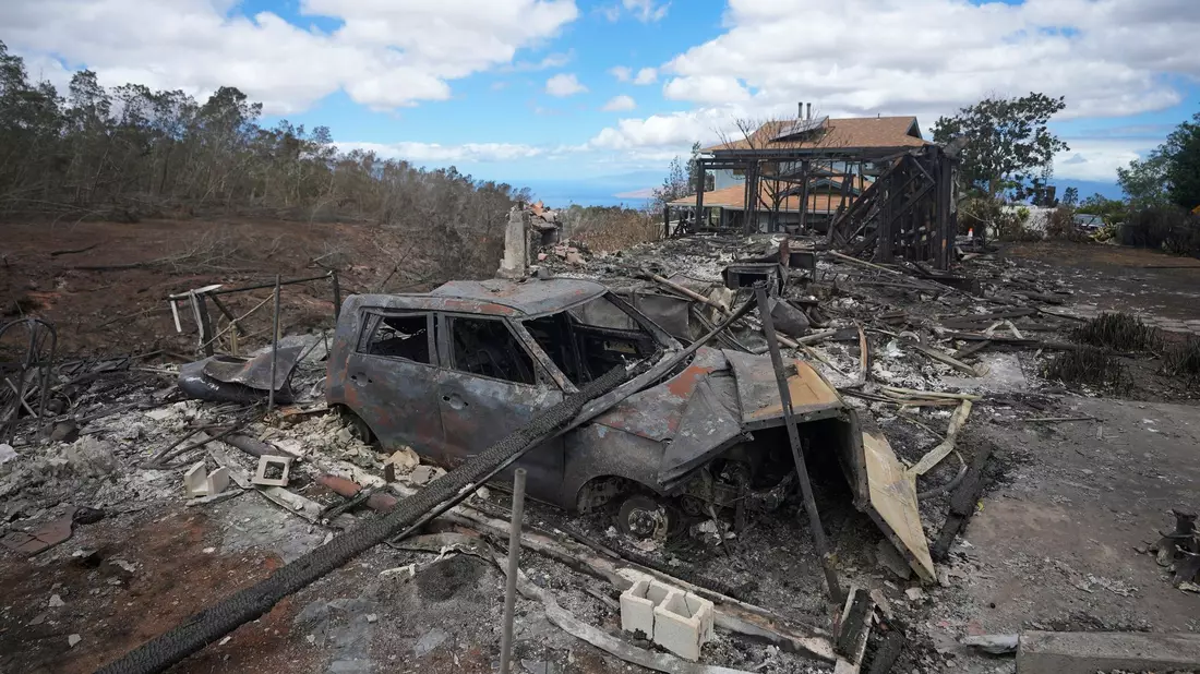Die verkohlten Überreste eines Fahrzeugs stehen  in Kula neben einem von einem Waldbrand zerstörten Haus. - Bild: Rick Bowmer/AP