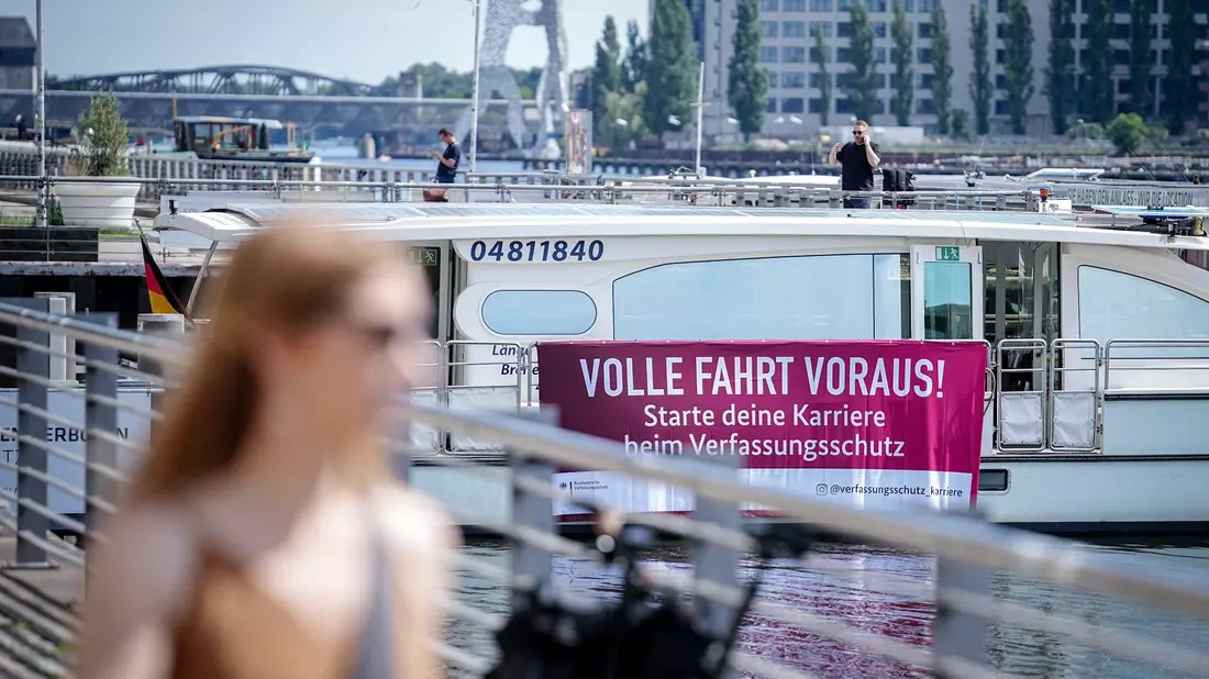 Mit einem Plakat an einem Solarschiff wirbt der nationale Nachrichtendienst für Nachwuchs. - Bild: Kay Nietfeld/dpa