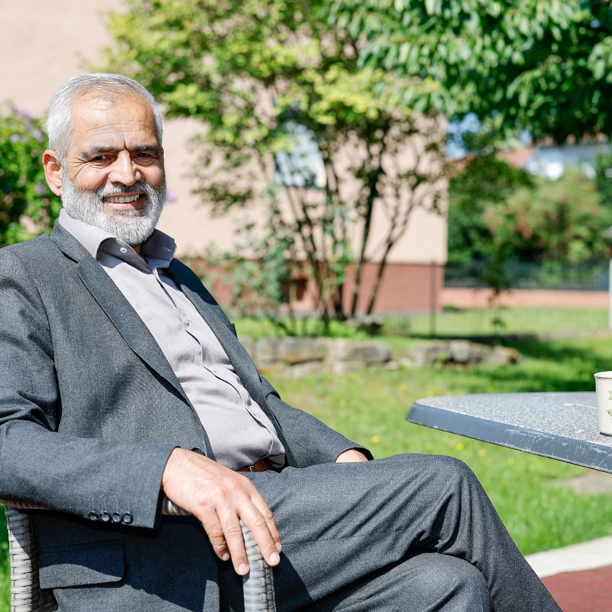 Mohammed Tarik aus Afghanistan sitzt im Garten seines Mietshauses. Er lebt seit Oktober 2022 mit seiner Frau und zwei Töchtern in einem Dorf bei Bamberg (Bayern). - Foto: Daniel Löb/dpa