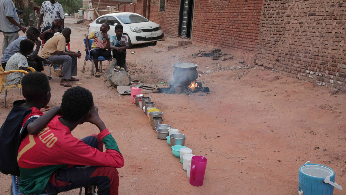 Menschen bereiten in einem Viertel von Khartum Essen zu. - Foto: -/AP/dpa