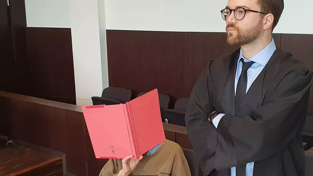 Der Angeklagte (l) sitzt neben seinem Verteidiger Maximilian Klefenz im Verhandlungssaal des Düsseldorfer Landgerichts und verdeckt sein Gesicht. - Bild: Martin Höke/dpa