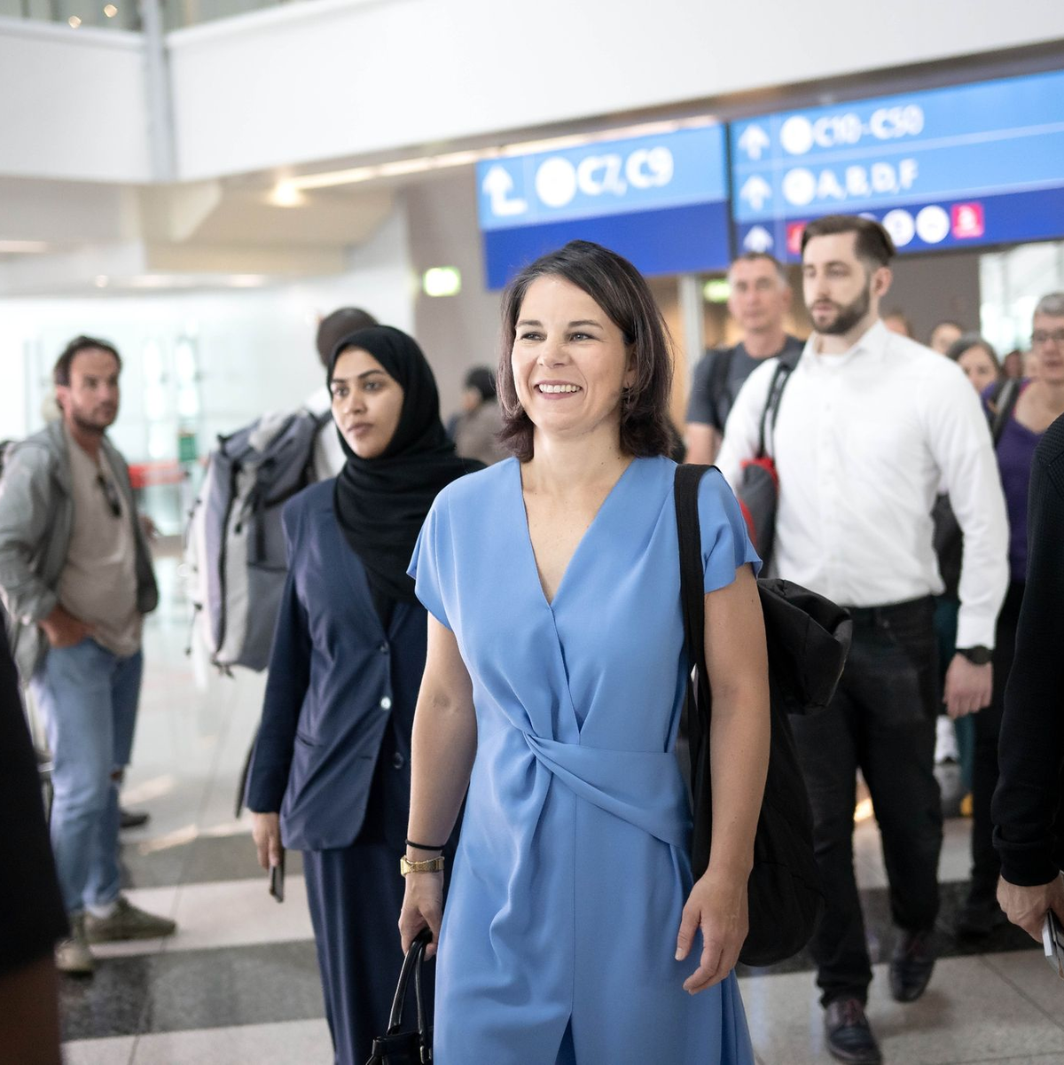 Außenministerin Annalena Baerbock (M, Bündnis 90/Die Grünen) ist auf dem Flughafen in Dubai auf dem Weg zu ihrem Flug. - Foto: Sina Schuldt/dpa
