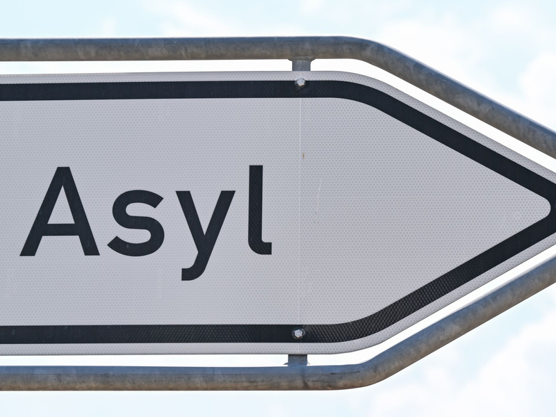 Das Wort «Asyl» steht auf einem Wegweiser zur Erstaufnahme-Einrichtungen (EAE) des Landes Brandenburg in Eisenhüttenstadt. - Foto: Patrick Pleul/dpa