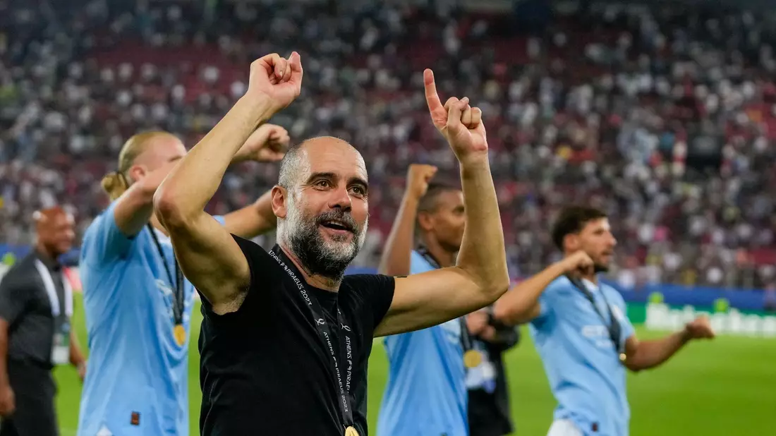 Manchester Citys Trainer Pep Guardiola feiert mit seinen Spielern den Sieg im Supercup. - Bild: Thanassis Stavrakis/AP/dpa