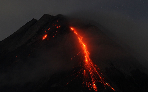 Der orange-rote Lavastrom leuchtet in der Dunkelheit. - Foto: Angga Budhiyanto/ZUMA Press Wire/dpa