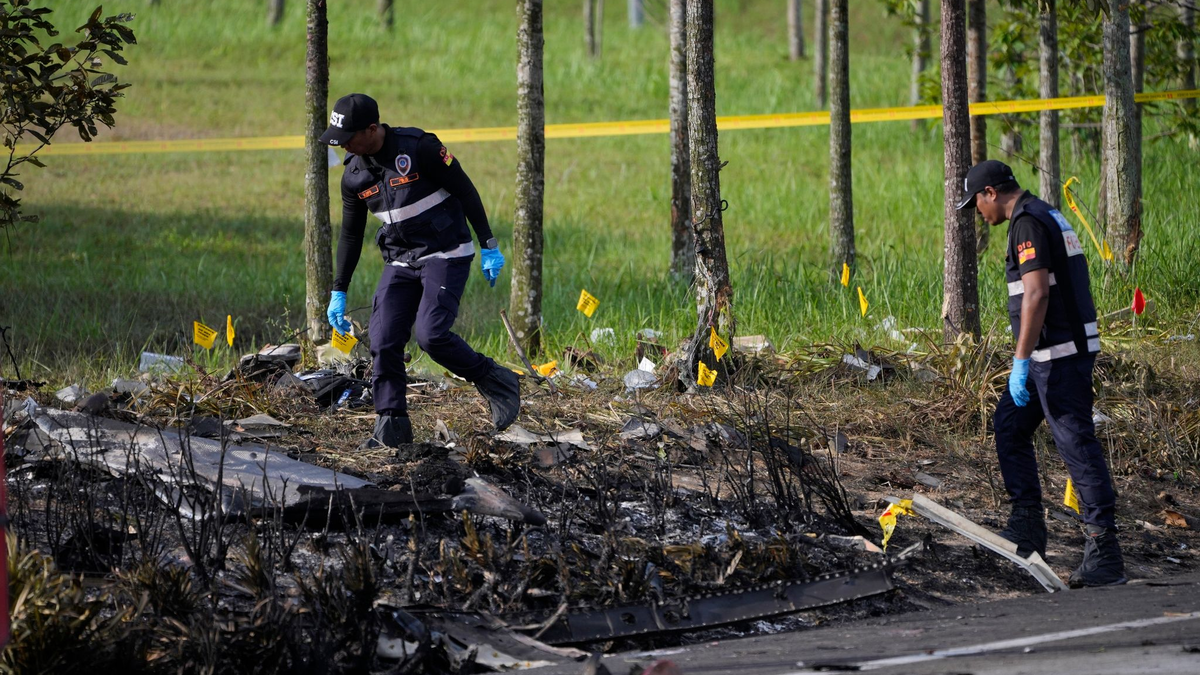 Polizisten ermittelt an der Absturzstelle des Kleinflugzeugs in Malaysia. - Foto: Vincent Thian/AP