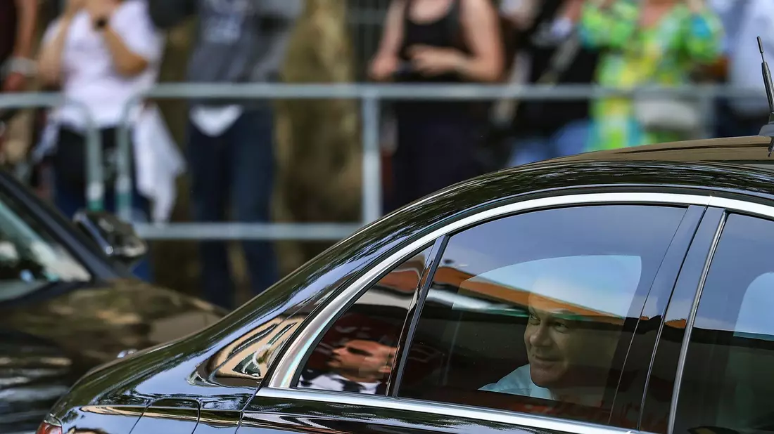 Bundeskanzler Olaf Scholz blickt aus seinem Dienstwagen. - Bild: Oliver Berg/dpa