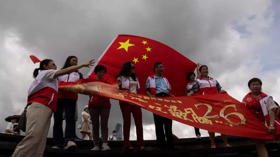 Peking-Befürworter halten chinesische Fahnen anlässlich des 26. Jahrestages der Übergabe der Kontrolle über Hongkong von Großbritannien an China. Führende EU-Vertreter erheben mit einem neuen Bericht zu den Entwicklungen in Hongkong schwere Vorwürfe gegen die politische Führung in Peking. - Bild: Louise Delmotte/AP/dpa