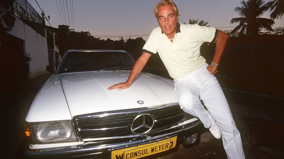 Hans-Hermann Weyer, bekannt durch den Verkauf von Titeln und Adelsprädikaten,  posiert auf seinem Wagen (1985). - Bild: Istvan Bajzat/dpa
