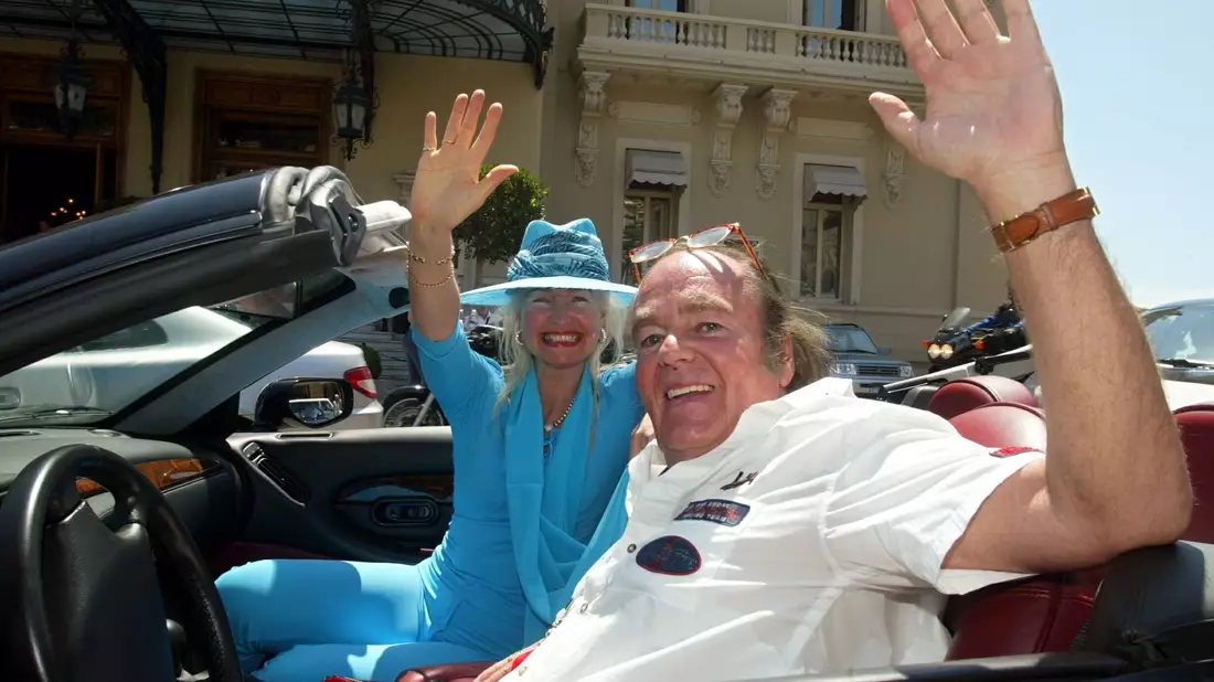 Hans-Hermann Weyer und seine Ehefrau Christina winken aus ihrem Aston Martin-Cabriolet (2002). - Bild: Gero Breloer/dpa