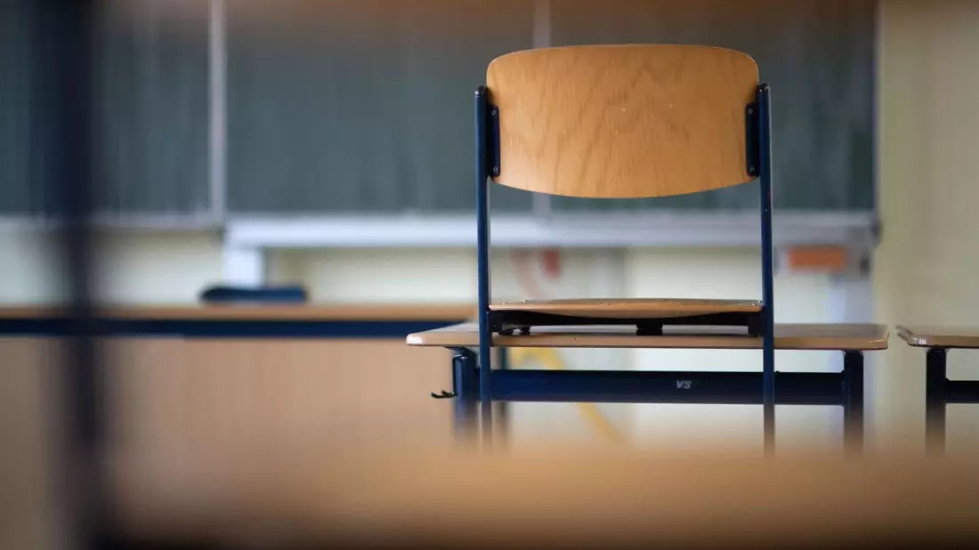 Ein Stuhl steht in einem Klassenzimmer einer Realschule auf einem Tisch. - Bild: Marijan Murat/dpa