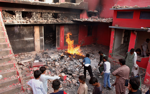 Jugendliche stehen in Jaranwala vor einer Kirche, die beschÀdigt und niedergebrannt wurde. - Foto: Muhammad Shafqat/AP/dpa Jugendliche stehen in Jaranwala vor einer Kirche, die beschÀdigt und niedergebrannt wurde. - Foto: Muhammad Shafqat/AP/dpa