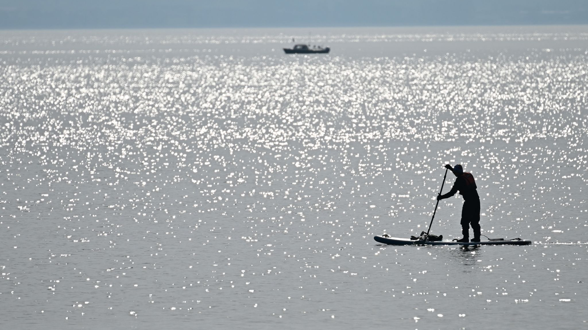 Ein Stand-up-Paddler paddelt über den Bodensee. (Symbolbild) - Foto: Felix Kästle/dpa