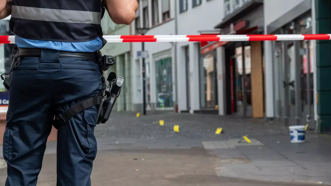 Ein Polizist sichert den Ort, wo in der Nacht auf Samstag ein junger Mann getötet worden ist. - Bild: Harald Tittel/dpa