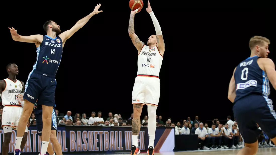 Deutschlands Daniel Theis (M) springt neben dem Griechen Giorgos Papagiannis zum Wurf hoch. - Bild: Matthias Stickel/dpa