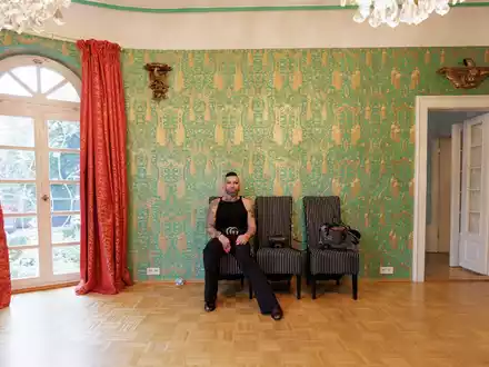 Harald Glööckler sitzt in einem nahezu leeren Raum seines alten Hauses. - Foto: Reiner Voss/View/dpa