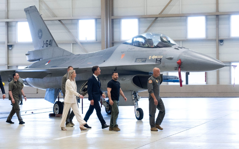 Wolodymyr Selenskyj (2.v.r) und Mark Rutte (M) laufen an einem F-16 Kampfjet vorbei. - Foto: Peter Dejong/AP/dpa