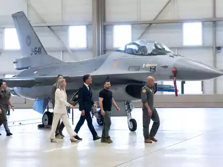 Wolodymyr Selenskyj (2.v.r) und Mark Rutte (M) laufen an einem F-16 Kampfjet vorbei. - Foto: Peter Dejong/AP/dpa