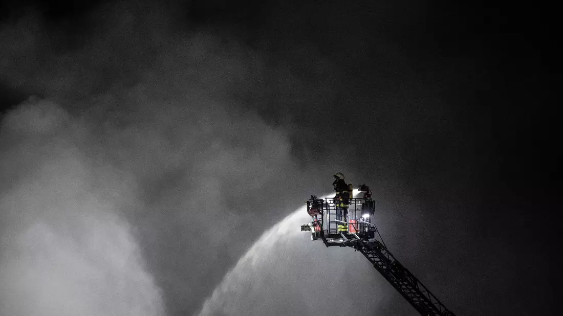 Feuerwehrleute bekämpfen einen Brand in einem Recycling-Betrieb für Batterien in Offenbach. - Bild: Boris Roessler/dpa