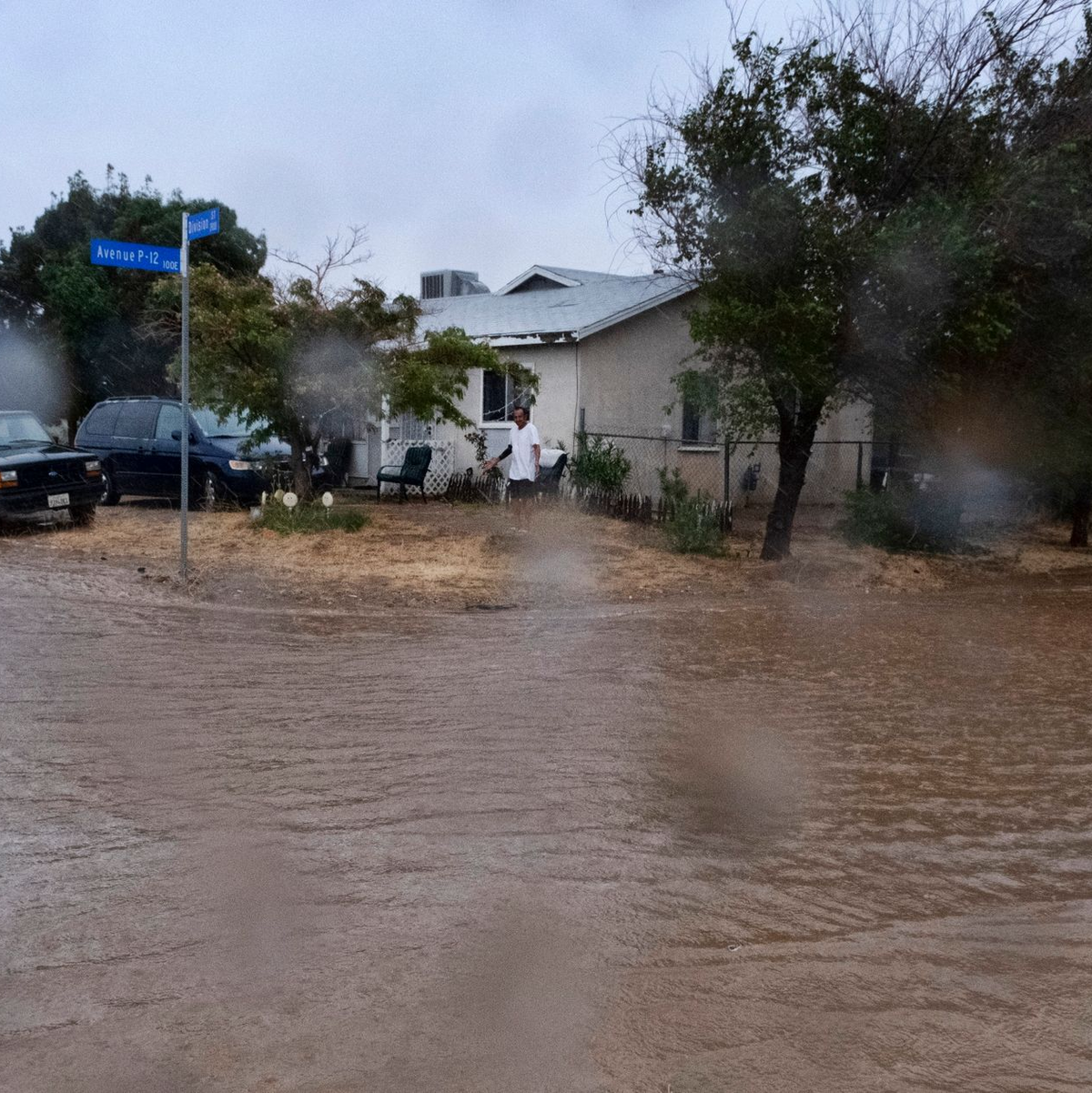 Ein Anwohner prüft während eines Regengusses in Palmdale die Überschwemmungen rund um sein Haus. - Foto: Richard Vogel/AP