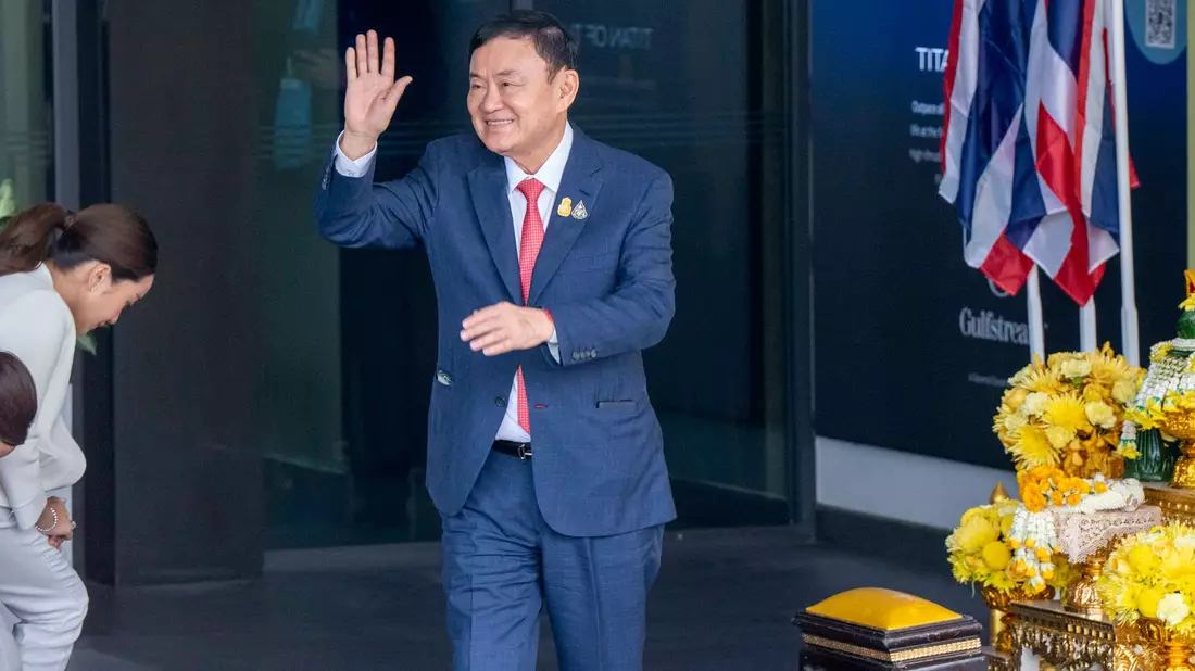Der ehemaliger Ministerpräsident von Thailand Thaksin Shinawatra winkt seinen Anhängern auf dem internationalen Flughafen Don Mueng in Bangkok zu. - Bild: Adryel Talamantes/ZUMA Press Wire/dpa