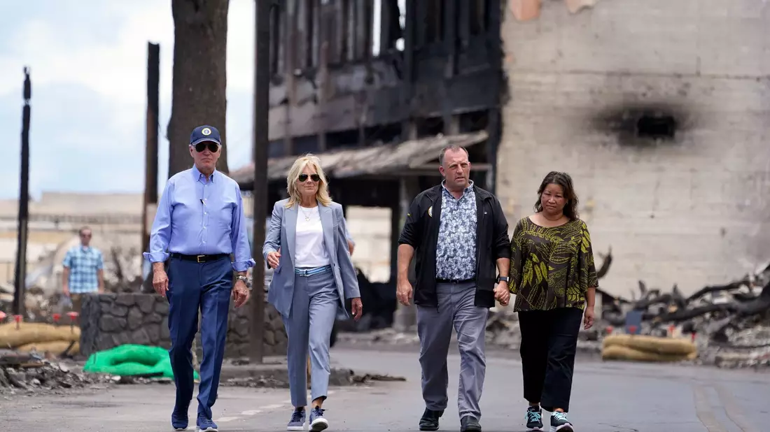 US-Präsident Joe Biden (l) und First Lady Jill Biden (2.v.l) gehen zusammen mit Josh Green, Gouverneur von Hawaii, und seiner Frau Jaime Green durch ein von Waldbränden auf der Insel Maui verwüstetes Gebiet. - Bild: Evan Vucci/AP