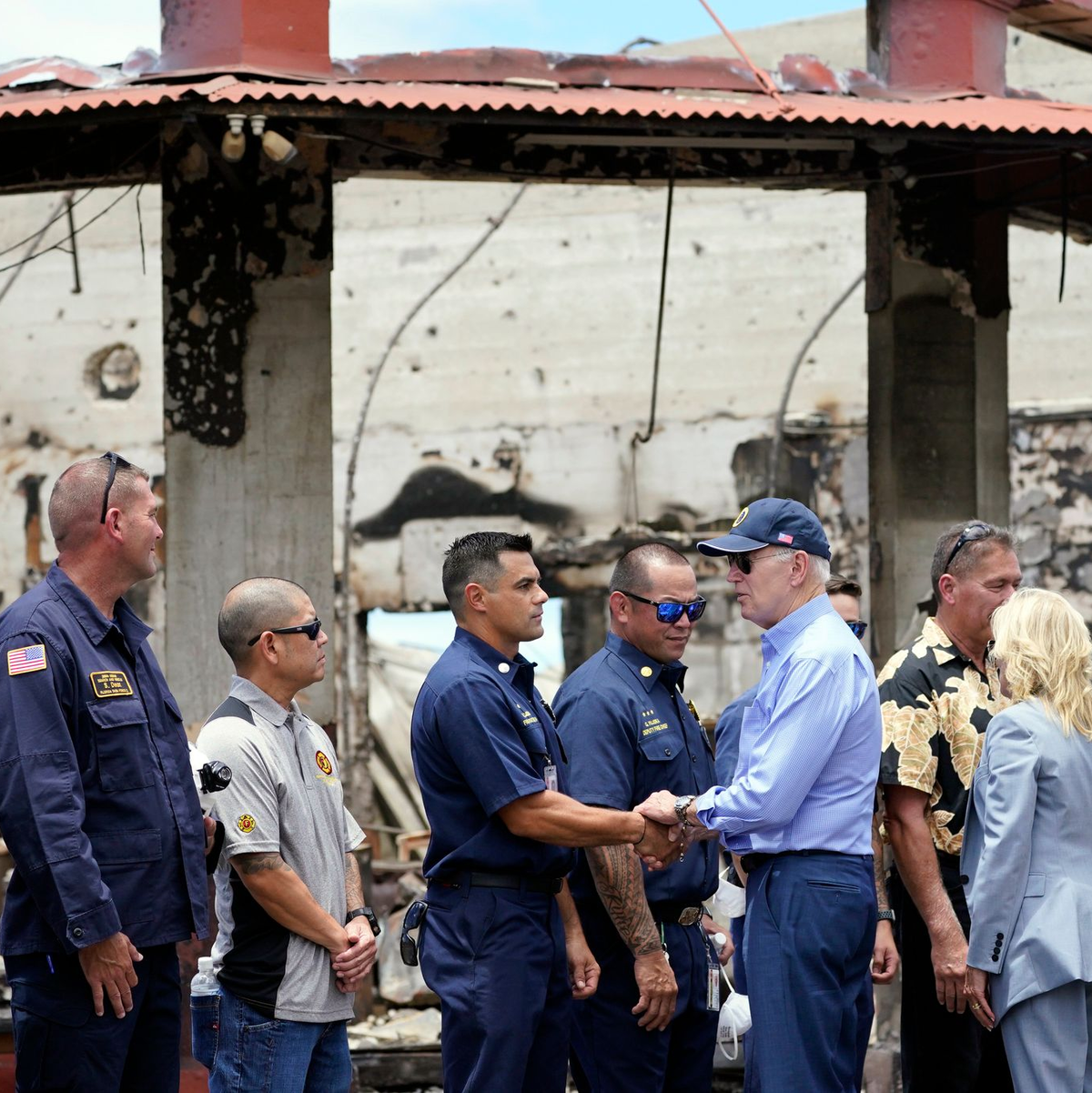 US-Präsident Joe Biden (6.v.l) und First Lady Jill Biden (3.v.r) begrüßen Ersthelfer, als sie von den Waldbränden auf Maui verwüstete Gebiete besuchen. - Foto: Evan Vucci/AP