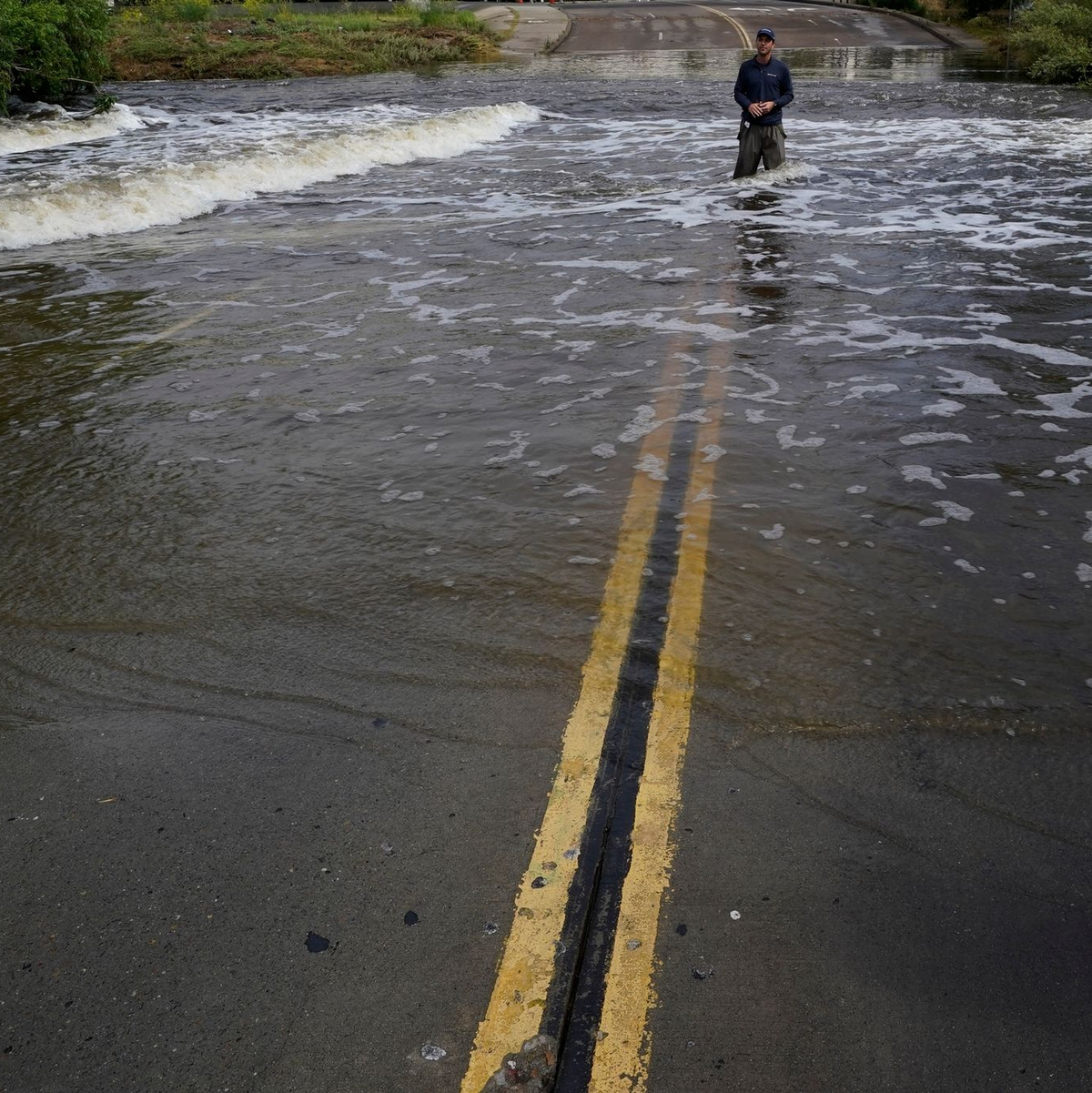 Ein Mann steht auf einer überfluteten Straße in San Diego nachdem Tropensturms «Hilary» durch das Gebiet gezogen war. - Foto: Gregory Bull/AP/dpa