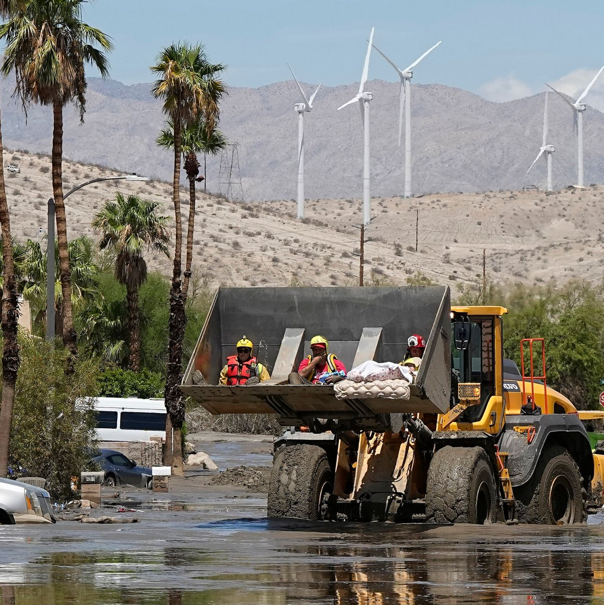Feuerwehrleute in Cathedral City setzen einen Bagger ein, um eine Person aus einem Zentrum für betreutes Wohnen zu retten, nachdem die Straße mit Schlamm überflutet wurde. - Foto: Mark J. Terrill/AP/dpa