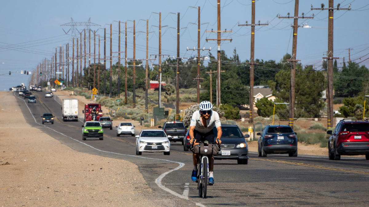 Der deutsche Athlet Jonas Deichmann fährt mit seinem Fahrrad eine Straße in den USA entlang. - Foto: Markus Weinberg/Jonas Deichmann/dpa