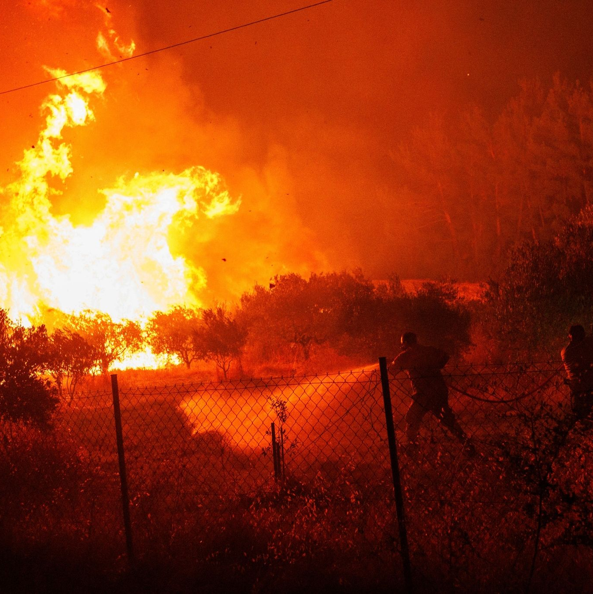 Ein Hubschrauber wirft Wasser über dem Dorf Avantas ab. Stürmische Winde fachen die Flammen der Waldbrände in ganz Griechenland an. - Foto: Achilleas Chiras/AP