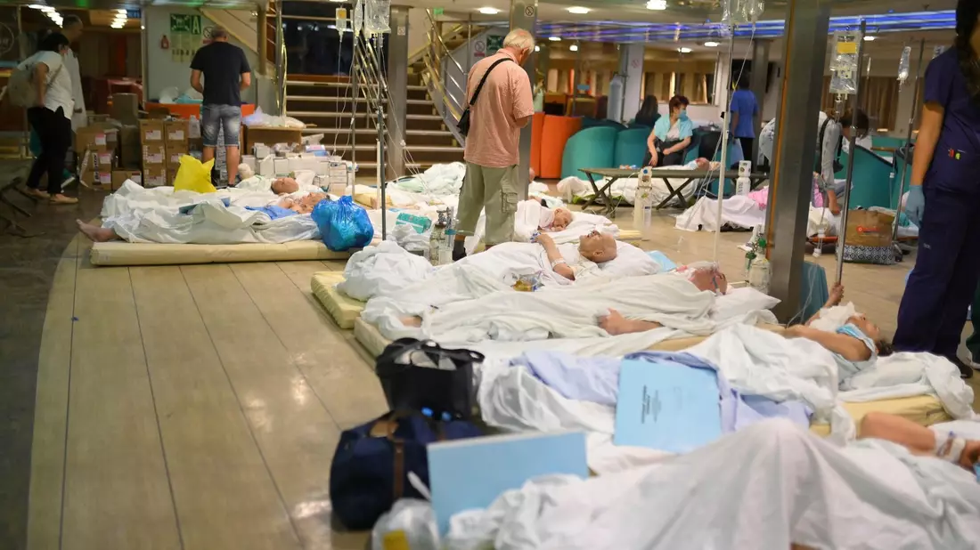 Patienten liegen auf dem Boden einer Fähre, nachdem die Gesundheitsbehörden ein Krankenhaus in Alexandroupolis teilweise evakuiert haben. - Bild: Uncredited/e-evros.gr/AP/dpa