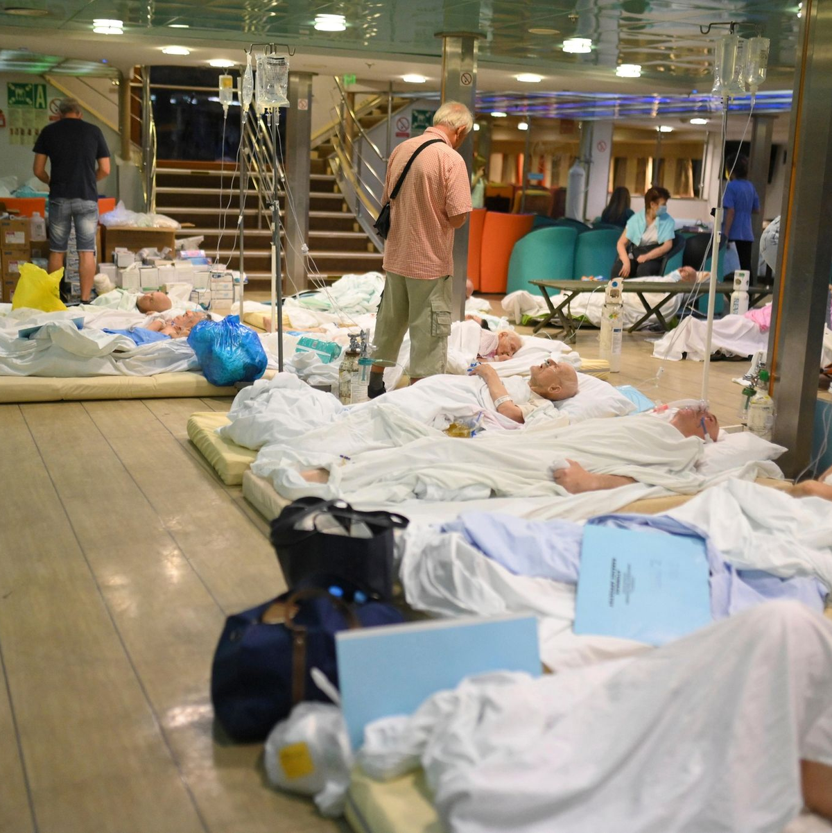 Patienten liegen auf dem Boden einer Fähre, nachdem die Gesundheitsbehörden ein Krankenhaus in Alexandroupolis teilweise evakuiert haben. - Foto: Uncredited/e-evros.gr/AP/dpa