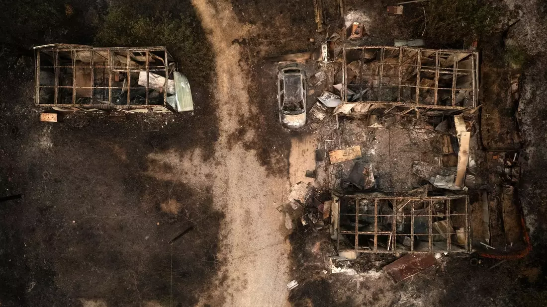 Ein verbranntes Auto und ausgebrannte Lagerhäuser in Palagia. - Bild: Achilleas Chiras/AP/dpa
