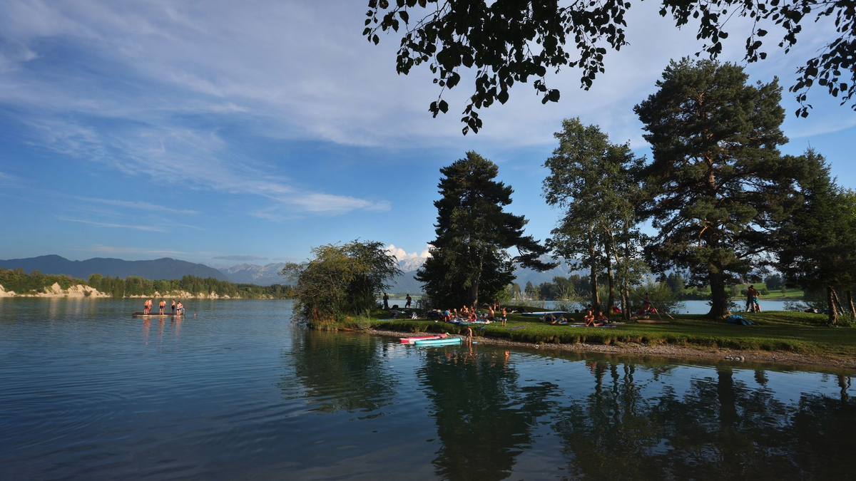Badegäste suchen Abkühlung in einer Bucht am Forggensee in Bayern. - Foto: Karl-Josef Hildenbrand/dpa