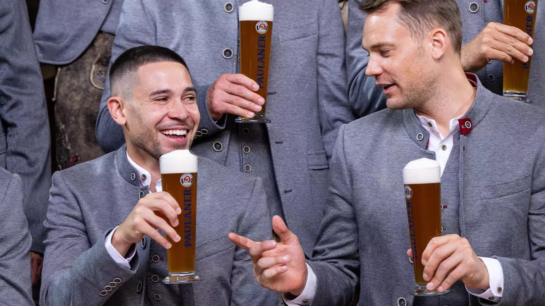 Raphael Guerreiro (l) und Manuel Neuer prosten beim jährlichen Fototermin vor dem Oktoberfest. - Bild: Lennart Preiss/dpa
