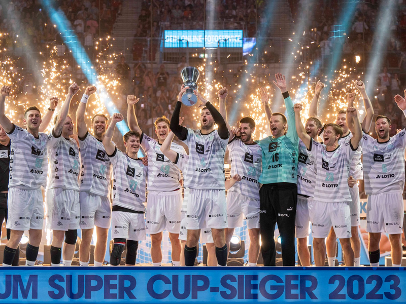 Kiels Domagoj Duvnjak (m) feiert mit seinen Teamkollegen den Supercup-Sieg. - Foto: David Inderlied/dpa