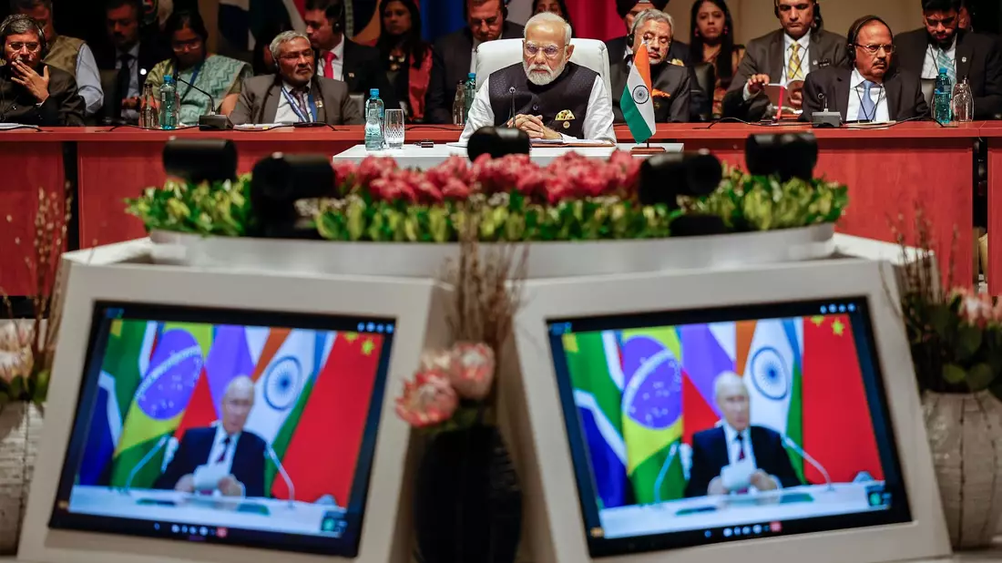 Indiens Premierminister Narendra Modi (M) schaut der Plenarsitzung auf dem Brics-Gipfel 2023 zu, während Kremlchef Wladimir Putin per Videoübertragung spricht. - Bild: GIANLUIGI GUERCIA/Pool AFP/AP/dpa
