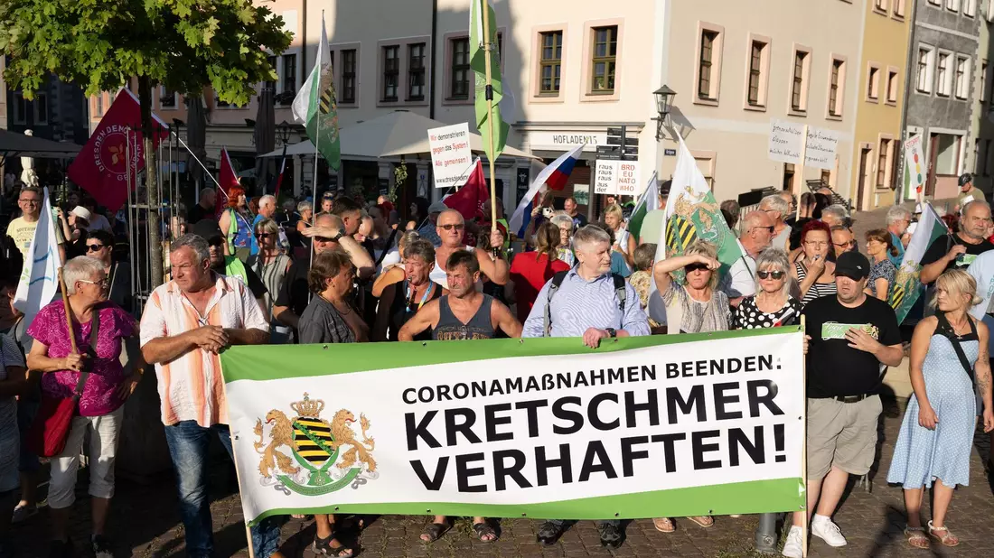 Die rechtsextreme Kleinstpartei «Freie Sachsen» war mit ein paar Dutzenden Anhängern unter anderem mit einem Plakat und der Aufschrift «Kretschmer verhaften» aufmarschiert. - Bild: Sebastian Kahnert/dpa