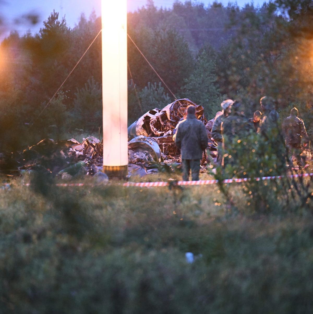 Einsatzkräfte am Absturzort in der Nähe des Dorfes Kuschenkino. Über die Ursache des Absturzes gibt es bislang nur Spekulationen. - Foto: Uncredited/AP/dpa