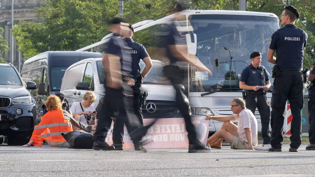 Polizisten halten an der Kreuzung am Stachus in der Münchner Innenstadt Klimaaktivisten der Letzten Generation fest. - Bild: Peter Kneffel/dpa