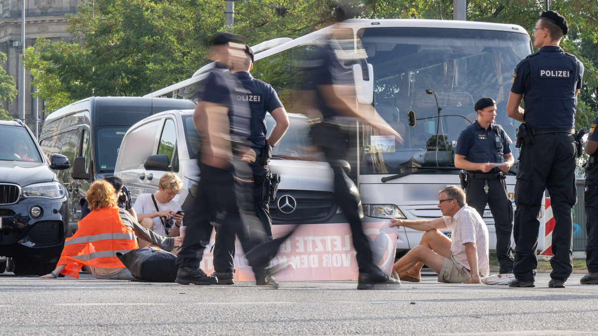 Polizisten halten an der Kreuzung am Stachus in der Münchner Innenstadt Klimaaktivisten der Letzten Generation fest. - Foto: Peter Kneffel/dpa