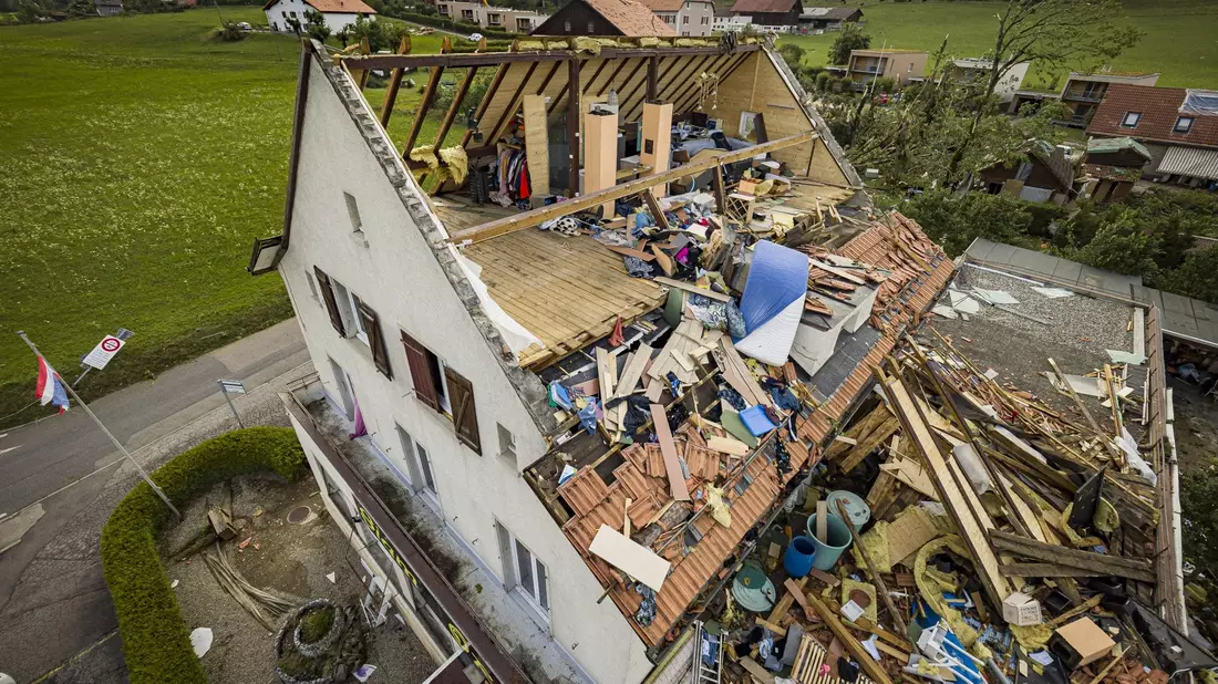 Ein Haus mit abgerissenem Dach, nachdem ein Tornado durch die Stadt La Chaux-de-Fonds in der Schweiz gefegt ist. - Bild: Valentin Flauraud/KEYSTONE/dpa