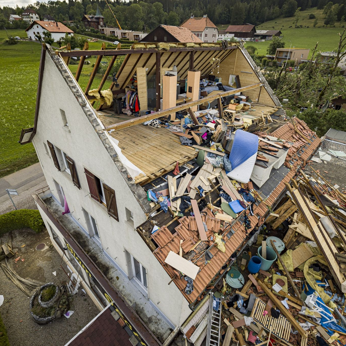 Ein Haus mit abgerissenem Dach, nachdem ein Tornado durch die Stadt La Chaux-de-Fonds in der Schweiz gefegt ist. - Foto: Valentin Flauraud/KEYSTONE/dpa