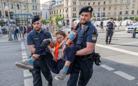 Polizisten tragen auf der Kreuzung am Stachus in der Münchener Innenstadt Aktivisten der Letzten Generation weg. Ihre Aktionen werden teilweise verboten. - Foto: Peter Kneffel/dpa