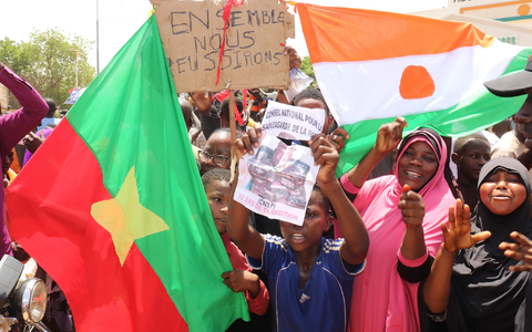 Befürworter des Putschs halten eine Flagge von Burkina Faso (l) und Niger hoch. Die beiden Länder haben einen Pakt geschlossen. - Foto: Djibo Issifou/dpa